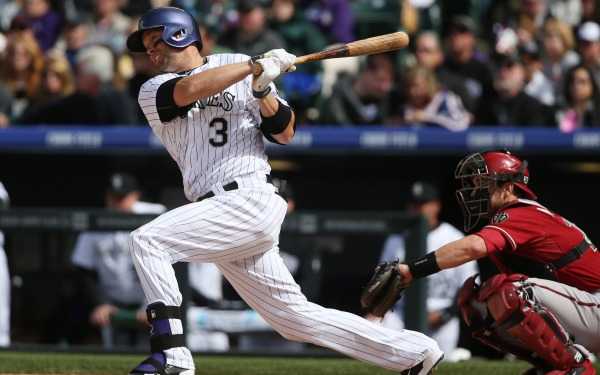 Colorado Rockies' Michael Cuddyer, left, doubles as Arizona Diamondbacks ctcher Miguel Montero looks on in the fourth inning of a baseball game in Denver on Sunday, April 6, 2014. (AP Photo/David Zalubowski)